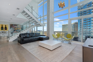 A bright, luxury apartment living room with floor-to-ceiling windows and a city view, perfectly detailed by a professional apartment cleaning service in Marietta, GA.