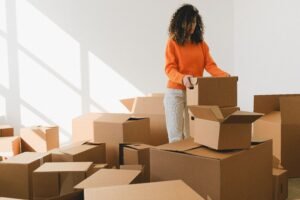 A homeowner packing cardboard boxes in a spotless room during a professional move-out cleaning service in Marietta, GA.