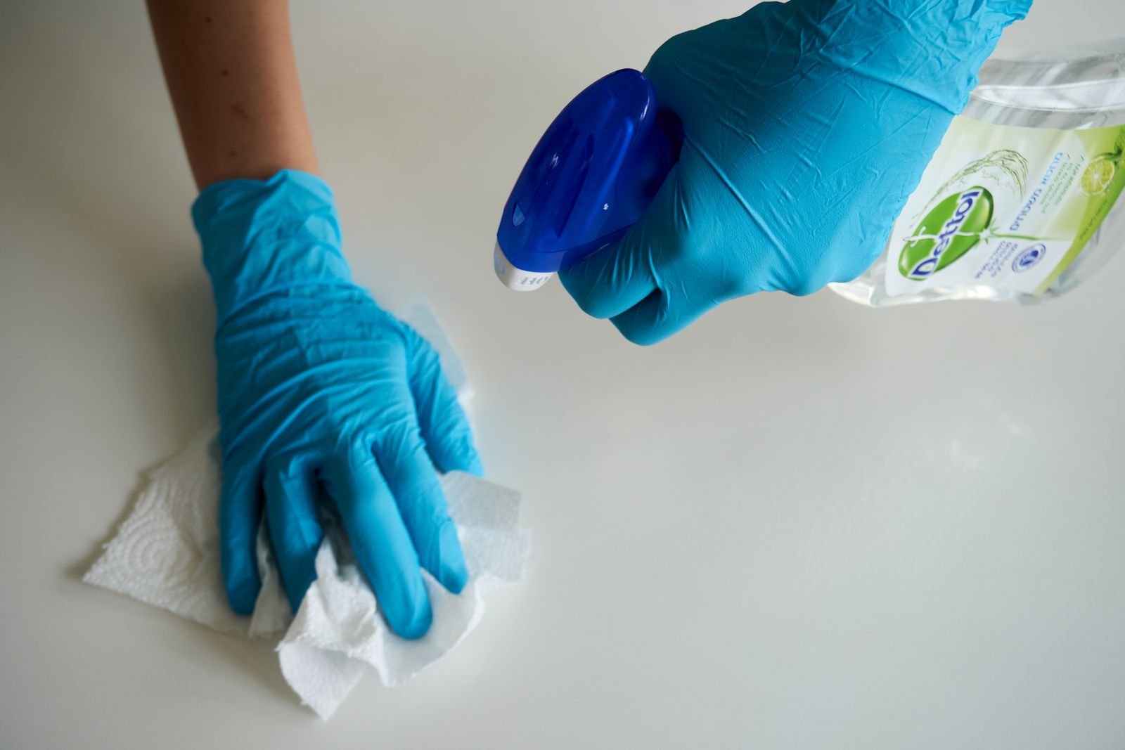 Professional wiping a surface with gloves, illustrating house cleaning cost in Marietta, GA
